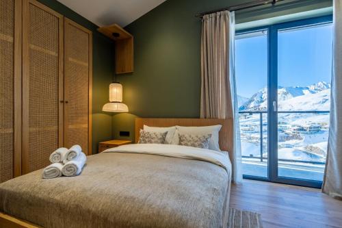 une chambre avec un lit et une grande fenêtre dans l'établissement Chioni House, à Kʼumlistsʼikhe