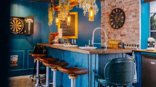 un bar con paredes azules y taburetes de madera en Expérience unique, thèmes & jeux à Strasbourg, appartement en duplex, en Estrasburgo
