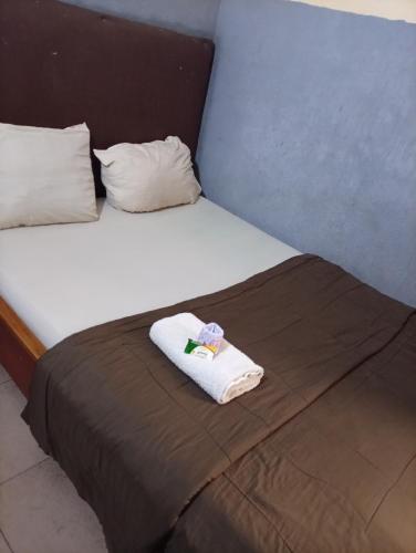 a bed with a towel sitting on top of it at GAT Travellers Hotel in Lagos