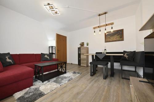 a living room with a red couch and a table at Haus Carmen Kleboth in Gaschurn