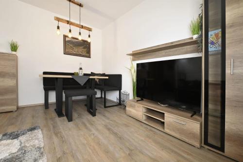 a living room with a table and a large television at Haus Carmen Kleboth in Gaschurn