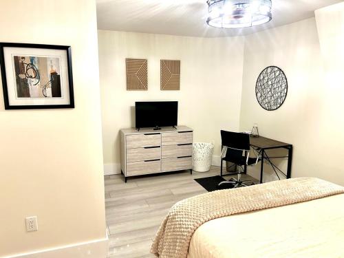 a bedroom with a bed and a desk and a television at Mod Abode 2 bdrm Highland UofR Downtown in Rochester