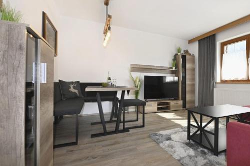 a living room with a table and a television at Haus Carmen Kleboth in Gaschurn