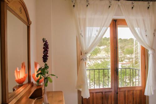 a room with a window and a mirror and a door at El Tossal in El Castell de Guadalest