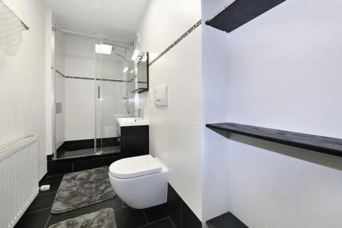 a white bathroom with a toilet and a sink at Haus Carmen Kleboth in Gaschurn
