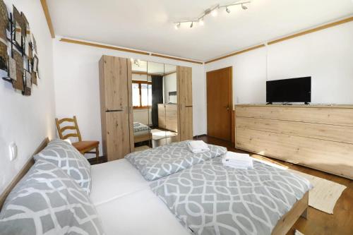 a bedroom with two beds and a flat screen tv at Haus Carmen Kleboth in Gaschurn