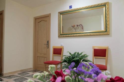 a room with a mirror and some chairs and flowers at El Tossal in El Castell de Guadalest