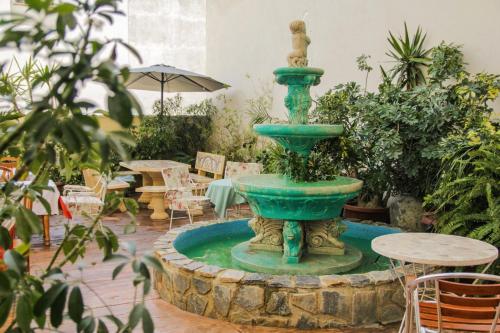 a large green fountain in the middle of a patio at El Tossal in El Castell de Guadalest