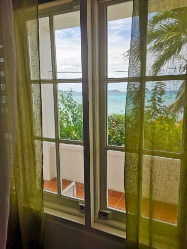 an open window with a view of the ocean at Green Roof Inn in Carriacou