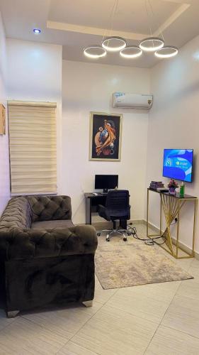 a living room with a couch and a desk at Percy Homes in Lekki