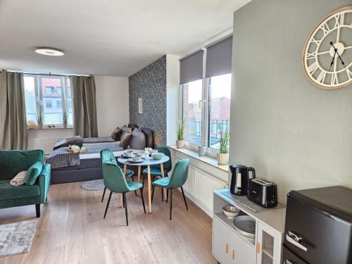 a living room with a table and chairs and a clock at Fewo Friends, 2 Apartments, Businesswohnung, Monteurzimmer in Salzgitter