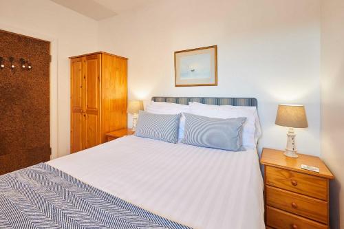 a bedroom with a white bed with blue pillows at Host & Stay - Spinnaker in Newton by the Sea