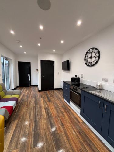 a living room with a couch and a clock on the wall at The Cosy Cabin, Cookstown in Cookstown