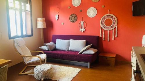a living room with a purple couch and a red wall at Naturnah bei Weimar in Nermsdorf