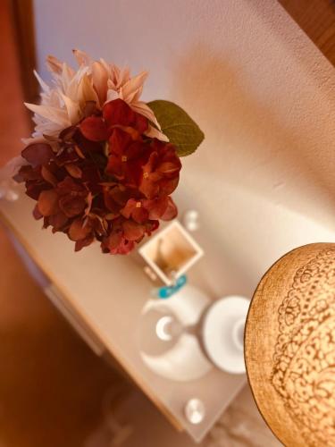 a vase with a flower on top of a table at Naturnah bei Weimar in Nermsdorf