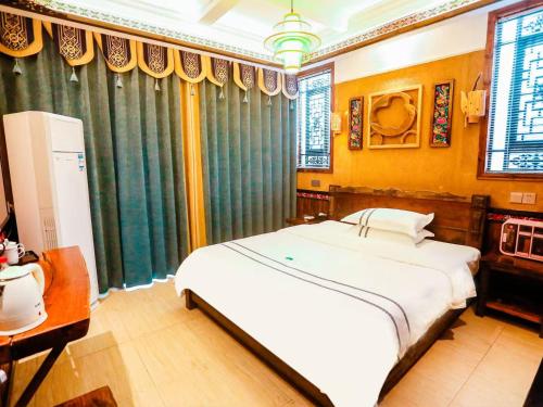 a bedroom with a large white bed in a room at Huaqianshu Theme Inn in Wang-ts'un