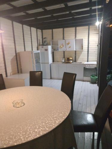 a kitchen with a table and chairs and a kitchen with white appliances at Casa rustica1 in Mamaia Nord