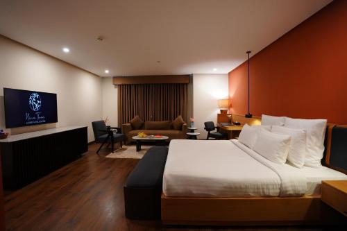 a hotel room with a bed and a living room at Nine Tree Luxury Hotel & Suites Lahore in Lahore