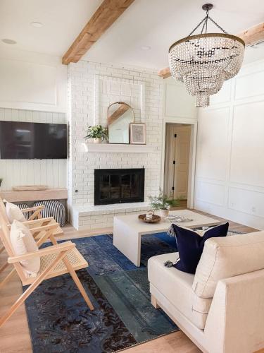 a living room with a chandelier and a fireplace at Luxe 4BR with Heated Pool and Hot Tub - Walk to Lake in Grapevine