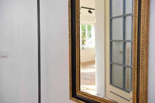 a mirror on a wall next to a door at Hallig Hüs 2 in Langeneß