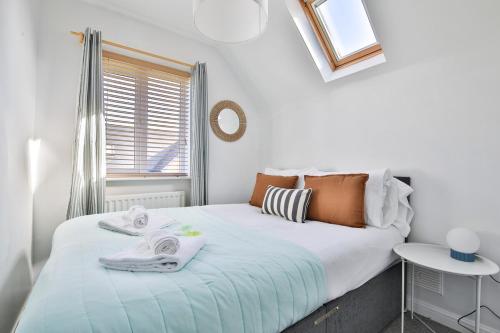 a bedroom with a bed with towels on it at Beach Breeze – Family 2-Bed Home in Barry in Barry