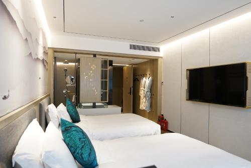 Un ou plusieurs lits dans un hébergement de l'établissement Paco Hotel Botanical Garden Metro Guangzhou-Free Shuttle Bus For Canton Fair