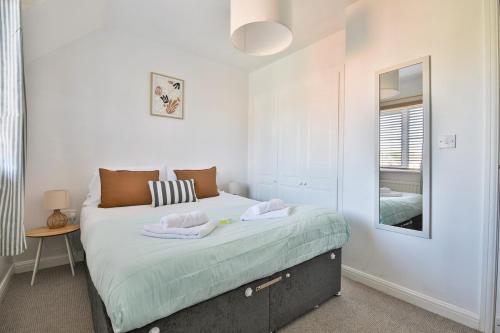 a bedroom with a bed with two towels on it at Beach Breeze – Family 2-Bed Home in Barry in Barry