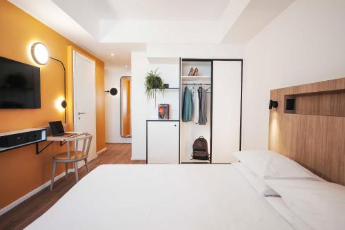 a bedroom with a large white bed and a desk at Aparthotel Colombo Roma in Rome