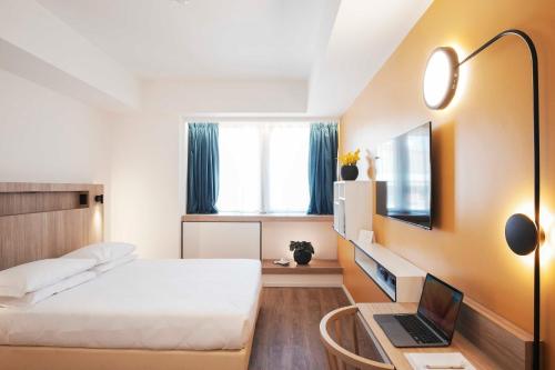 a bedroom with a bed and a laptop on a table at Aparthotel Colombo Roma in Rome