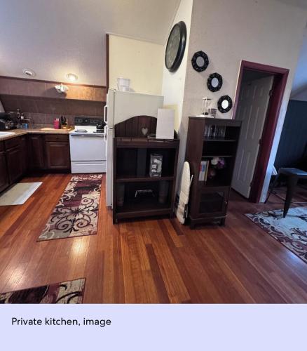 a kitchen with wooden floors and a white refrigerator at Ember Loft in Everett