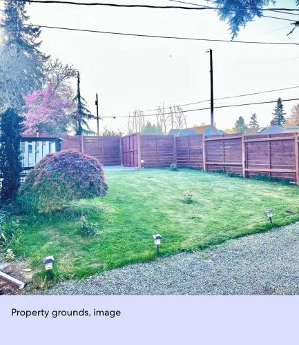 a yard with a fence and some lights in the grass at Ember Loft in Everett