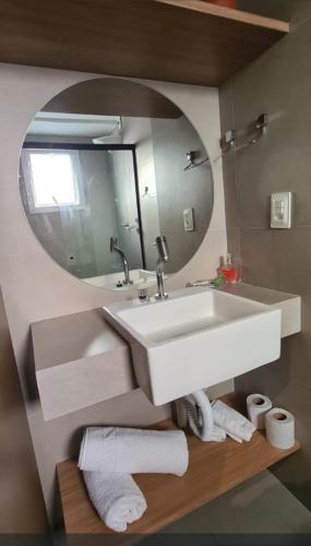 a bathroom with a white sink and a mirror at Flat Encantador Bauten Cabo Branco in João Pessoa