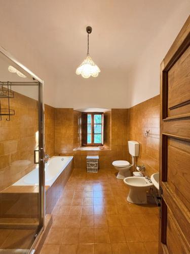 a bathroom with two toilets and a tub and sinks at Convento del Carmine 4 in Fivizzano