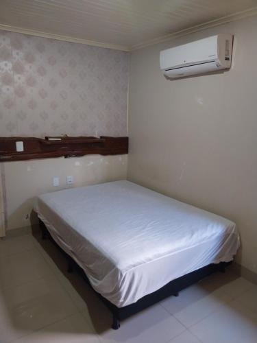 Habitación pequeña con cama blanca. en Chácara PontAlegre, en Rondonópolis