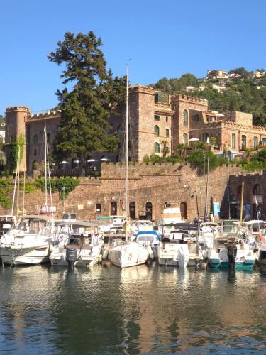 a bunch of boats docked in a harbor with a castle at Vue baie à 5min de la plage 44m² avec parking in Théoule-sur-Mer