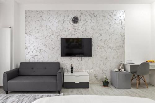 a living room with a couch and a tv on a wall at Selari Boutique in Bucharest