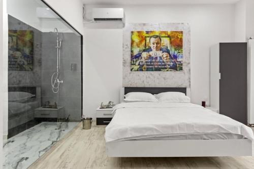a white bedroom with a large bed and a shower at Selari Boutique in Bucharest