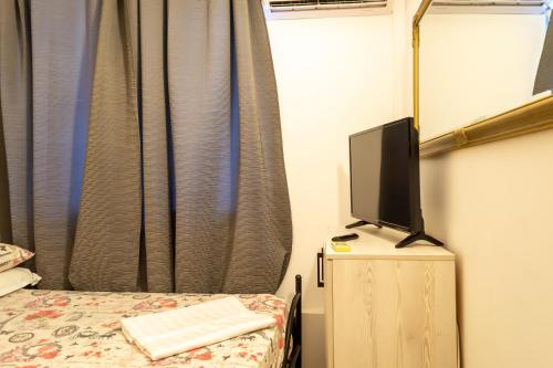a bedroom with a bed and a tv on a dresser at ElStefanino House in Eforie Nord