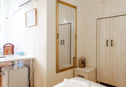 a bathroom with a mirror on the wall and a cabinet at ElStefanino House in Eforie Nord