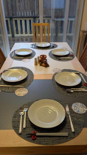 a wooden table with plates and utensils on it at Takayama Fortune-inn in Takayama