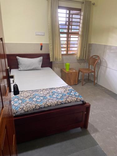 a bedroom with a bed and a chair and a window at Mp DREAMS ROOMS in Edappāl