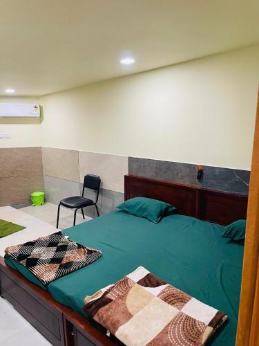 a bedroom with a green bed and a chair at Mp DREAMS ROOMS in Edappāl