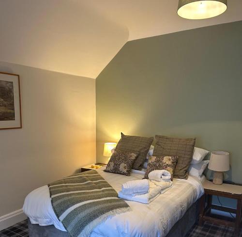 a bedroom with a bed with pillows on it at The Rhu Inn in Rhu