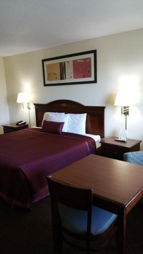 a hotel room with a large bed and two tables at Hoosier Inn- Portland in Portland