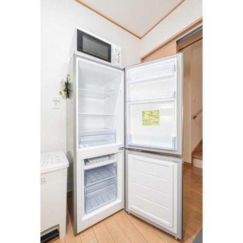 a refrigerator with its door open in a kitchen at Ohanachaya station 5-minute walk 4ldk house maxi 9people family friendly in Tokyo