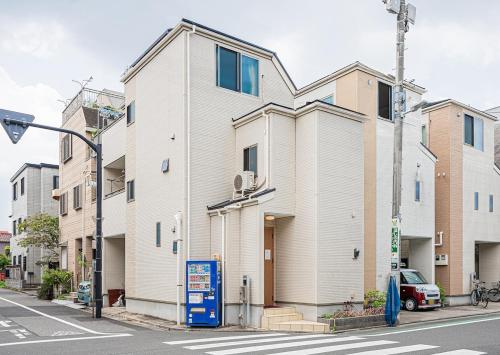 a white building on a city street with a street light at Ohanachaya station 5-minute walk 4ldk house maxi 9people family friendly in Tokyo