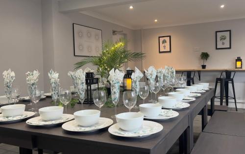 una mesa larga con platos, tazas y copas de vino en Conwy High Street Next To Marina, en Conwy