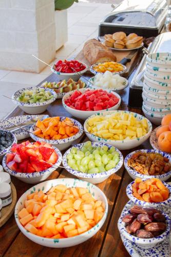 a table topped with bowls of different fruits and vegetables at Villa Gufo in Ostuni