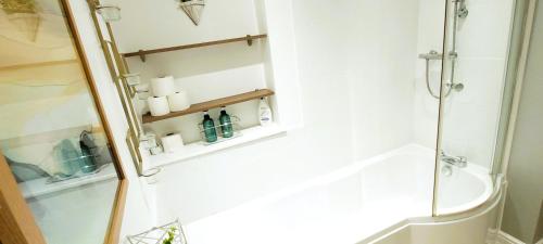a bathroom with a shower and a toilet and shelves at Wigan Central Executive Apartments I Family Rooms I Free Parking in Wigan