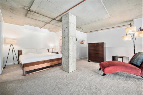 a bedroom with a bed and a red chair at Stylish City Loft Walk To Dining & Shops in Denver